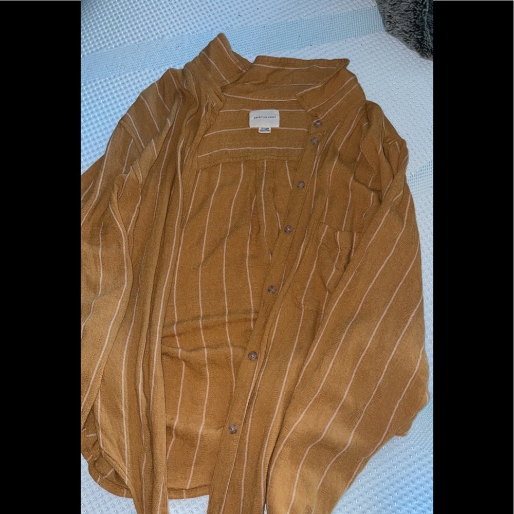 Mustard yellow long sleeve with white stripes . Buttons all the way up and ties.